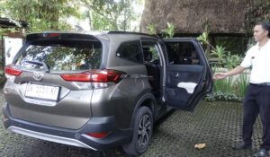 ホテル・テガルサリの送迎車と、車の横に立つホテルスタッフ